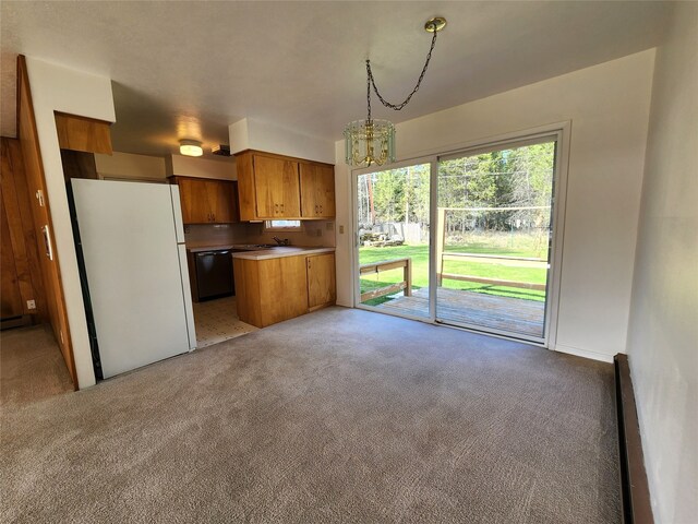 kitchen with pendant lighting, black dishwasher, brown cabinets, freestanding refrigerator, and open floor plan