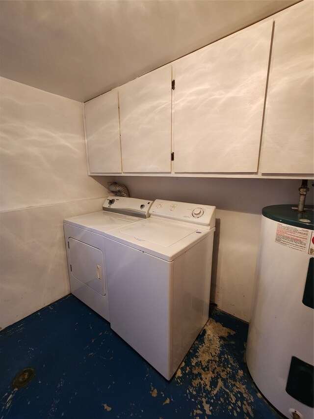 clothes washing area featuring cabinet space, washing machine and dryer, and electric water heater