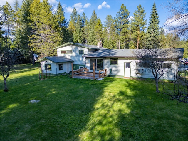 back of property featuring a chimney, a deck, and a lawn