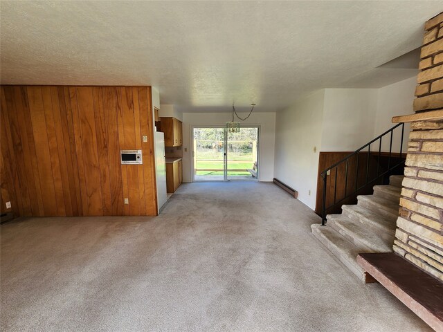 interior space with a baseboard heating unit, light carpet, and wooden walls