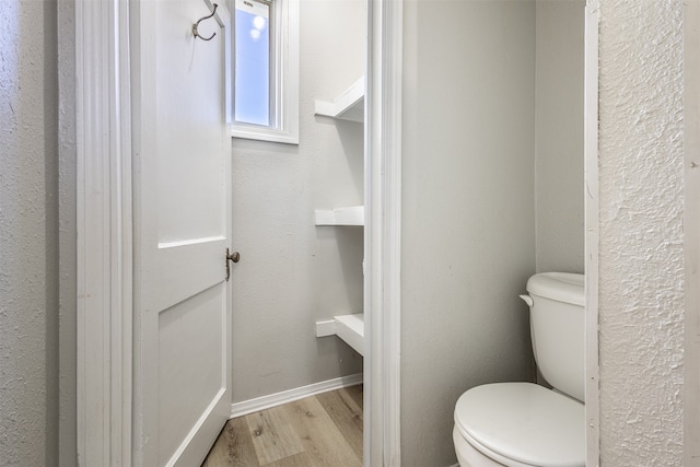 bathroom featuring hardwood / wood-style flooring and toilet