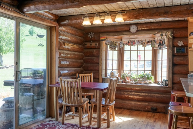 dining area with wood ceiling, light hardwood / wood-style flooring, plenty of natural light, and rustic walls