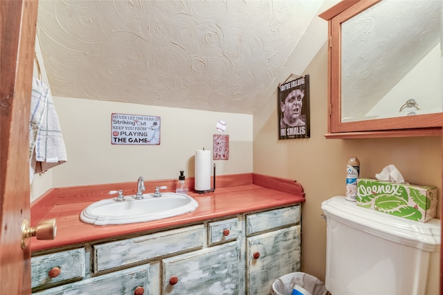 bathroom featuring toilet, oversized vanity, and vaulted ceiling