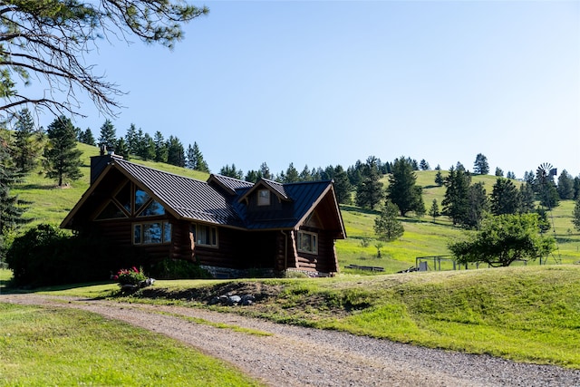 log-style house featuring a rural view and a front yard