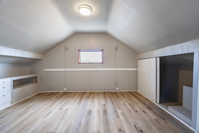 bonus room with lofted ceiling and light hardwood / wood-style floors