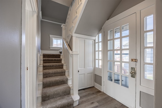 doorway featuring lofted ceiling and light hardwood / wood-style flooring