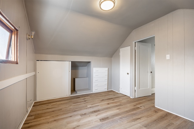 additional living space featuring vaulted ceiling and light hardwood / wood-style flooring