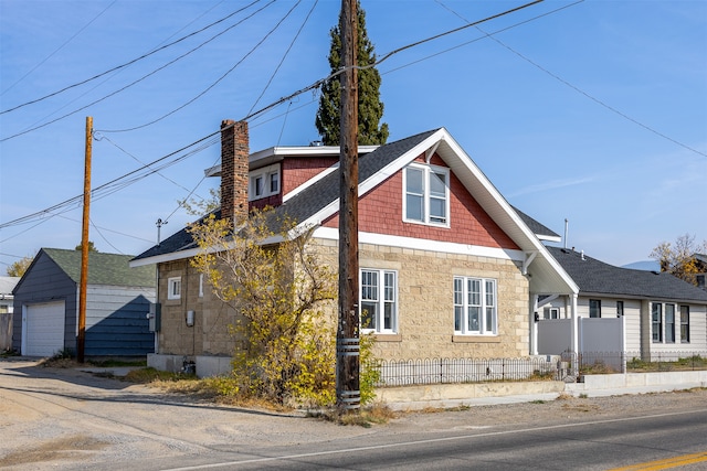 view of side of property with a garage and an outbuilding