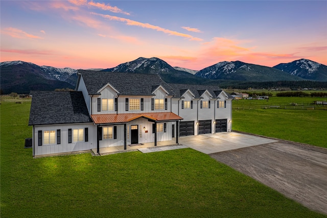 view of front of house featuring a mountain view, a garage, and a lawn