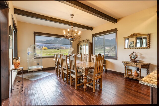 dining room with beamed ceiling, dark hardwood / wood-style floors, a mountain view, and an inviting chandelier