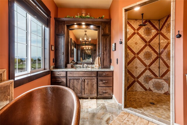 bathroom featuring tile floors, vanity with extensive cabinet space, a chandelier, and separate shower and tub