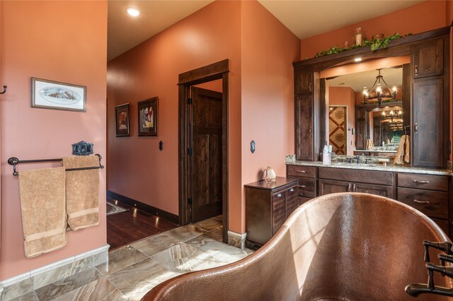 bathroom featuring tile flooring, large vanity, and an inviting chandelier