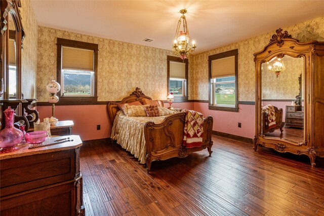 bedroom featuring dark hardwood / wood-style flooring and an inviting chandelier