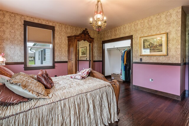 bedroom with a chandelier, dark wood-type flooring, and a closet