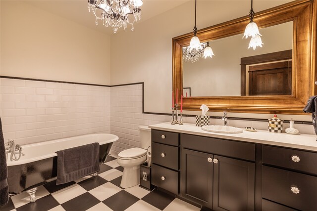 bathroom with tile floors, vanity, tile walls, an inviting chandelier, and toilet