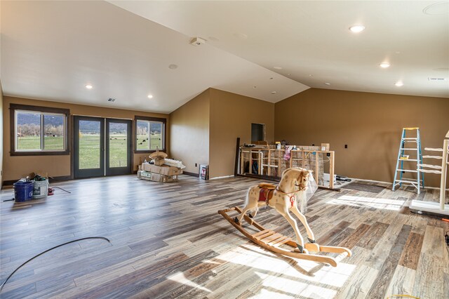 exercise area with hardwood / wood-style floors, vaulted ceiling, and french doors