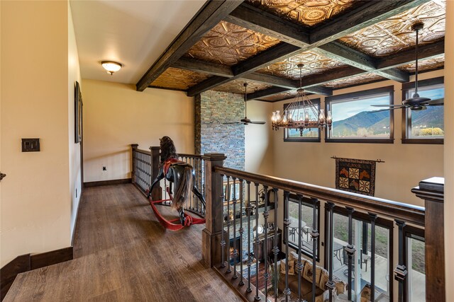 hall featuring dark wood-type flooring, beam ceiling, a notable chandelier, and coffered ceiling