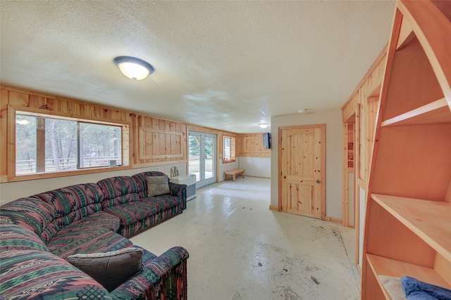 living room with wood walls and a textured ceiling