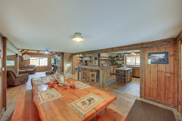 dining space with hardwood / wood-style flooring and wood walls