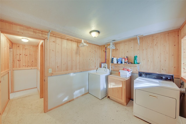 laundry area with washer and clothes dryer, wood walls, cabinets, and hookup for a washing machine