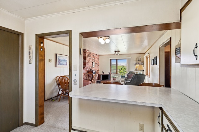 kitchen featuring light carpet, brick wall, and crown molding