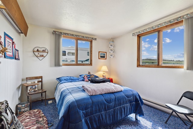 carpeted bedroom with a textured ceiling and multiple windows