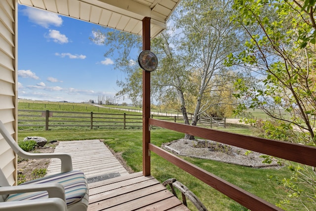 wooden terrace with a rural view and a lawn