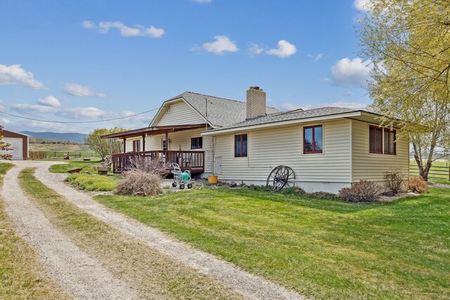 1848 Mountain View Orchard Rd, Corvallis, MT 59828 - rear view of property featuring a chimney, a yard, dirt driveway, and covered porch