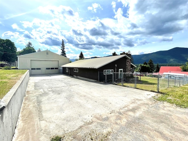 view of home's exterior with a mountain view, an outdoor structure, and a garage