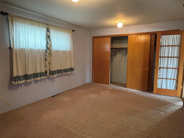 unfurnished bedroom featuring carpet flooring and a closet