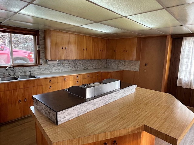 kitchen with decorative backsplash, a drop ceiling, and sink