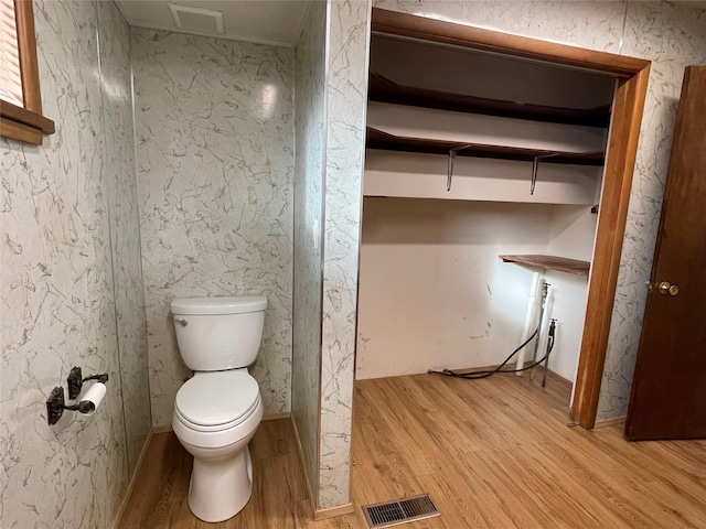 bathroom featuring wood-type flooring and toilet