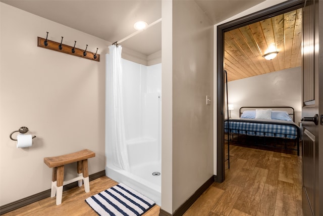 bathroom featuring hardwood / wood-style floors, wood ceiling, and a shower with shower curtain