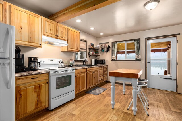 kitchen with sink, stainless steel appliances, beam ceiling, and light hardwood / wood-style floors