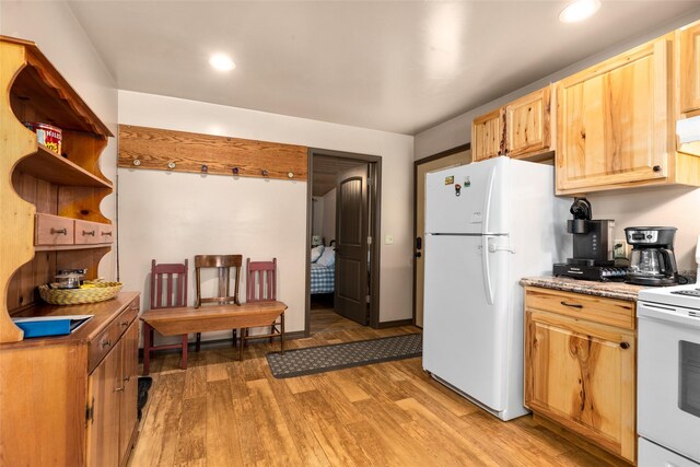 kitchen with hardwood / wood-style floors, light brown cabinetry, and white appliances