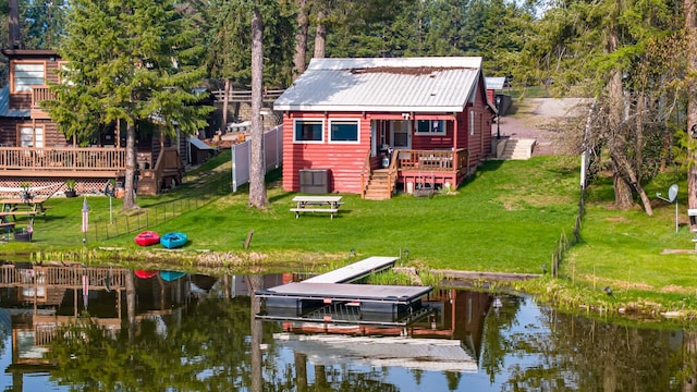 back of property featuring a yard, metal roof, central AC unit, and a deck with water view