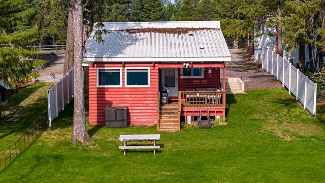 back of house with an outbuilding and a lawn