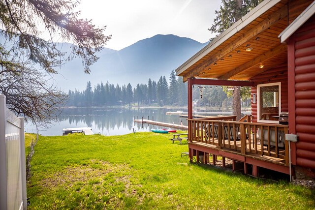 view of yard with a water and mountain view and a boat dock