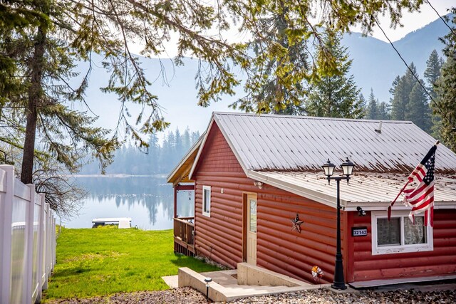 view of side of home featuring a water view and a yard