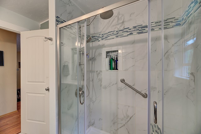 bathroom with walk in shower and hardwood / wood-style floors