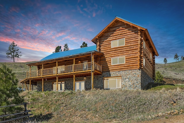 back house at dusk featuring a deck