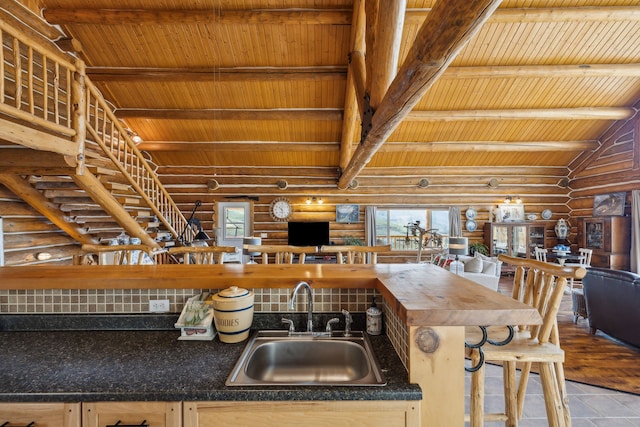 kitchen featuring sink, decorative backsplash, lofted ceiling with beams, and wood ceiling