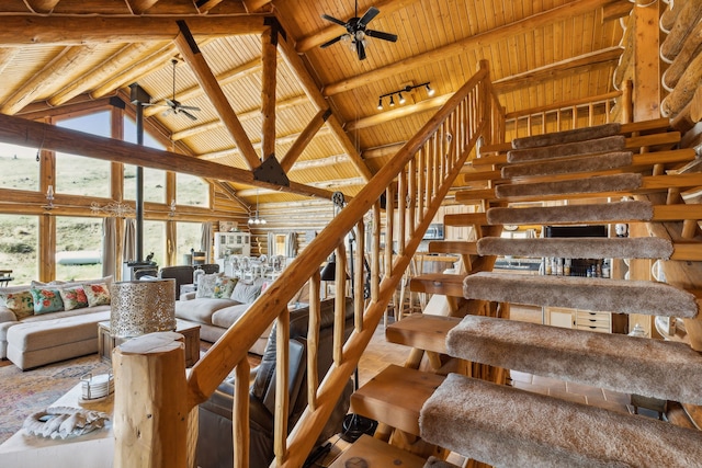 stairs featuring beam ceiling, ceiling fan, and wooden ceiling