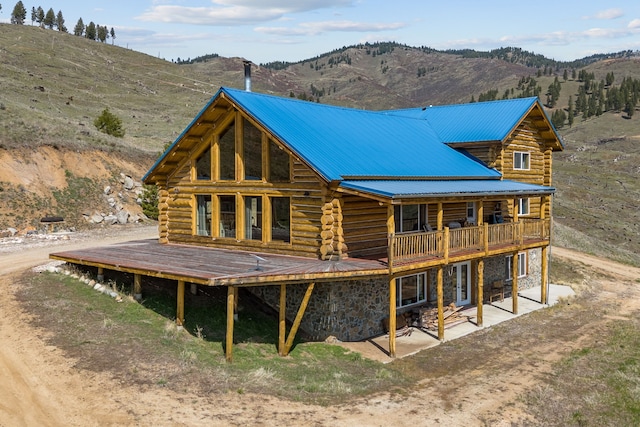 back of house with a mountain view and a patio