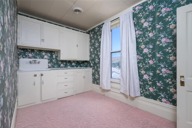 522 Hickory St, Anaconda, MT 59711 - kitchen featuring wallpapered walls, white cabinets, and light countertops