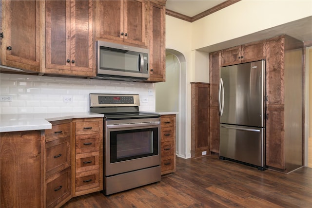 522 Hickory St, Anaconda, MT 59711 - kitchen featuring stainless steel appliances, ornamental molding, decorative backsplash, arched walkways, and light countertops
