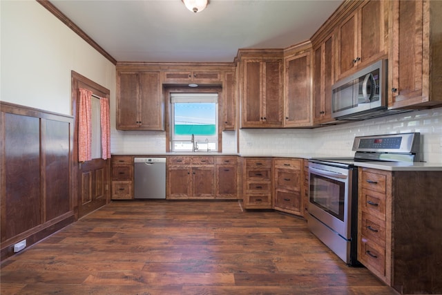 522 Hickory St, Anaconda, MT 59711 - kitchen with stainless steel appliances, dark wood-type flooring, decorative backsplash, light countertops, and a wainscoted wall