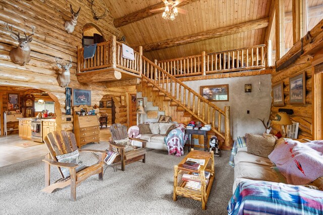 living area with arched walkways, high vaulted ceiling, wood ceiling, stairs, and beamed ceiling