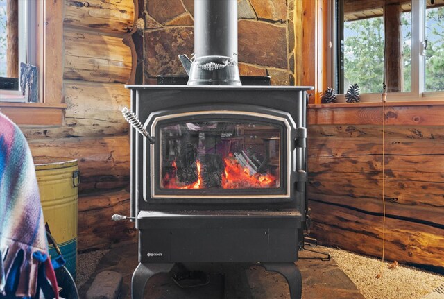 interior details with a wood stove and rustic walls