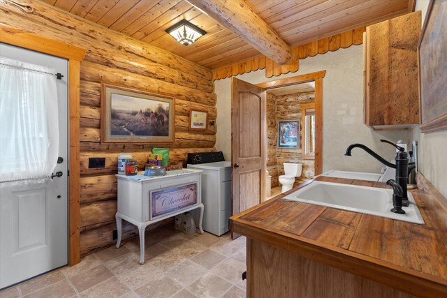 interior space featuring wooden ceiling, laundry area, a sink, washer / clothes dryer, and rustic walls